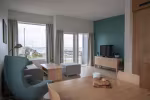 Person på terrassen og nyter utsikta mot fjøra og havet